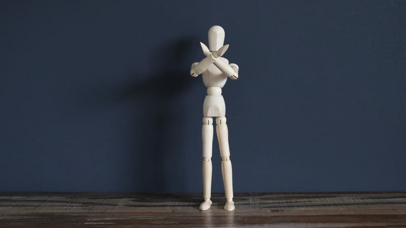 人形が手でバッテンをしている画像